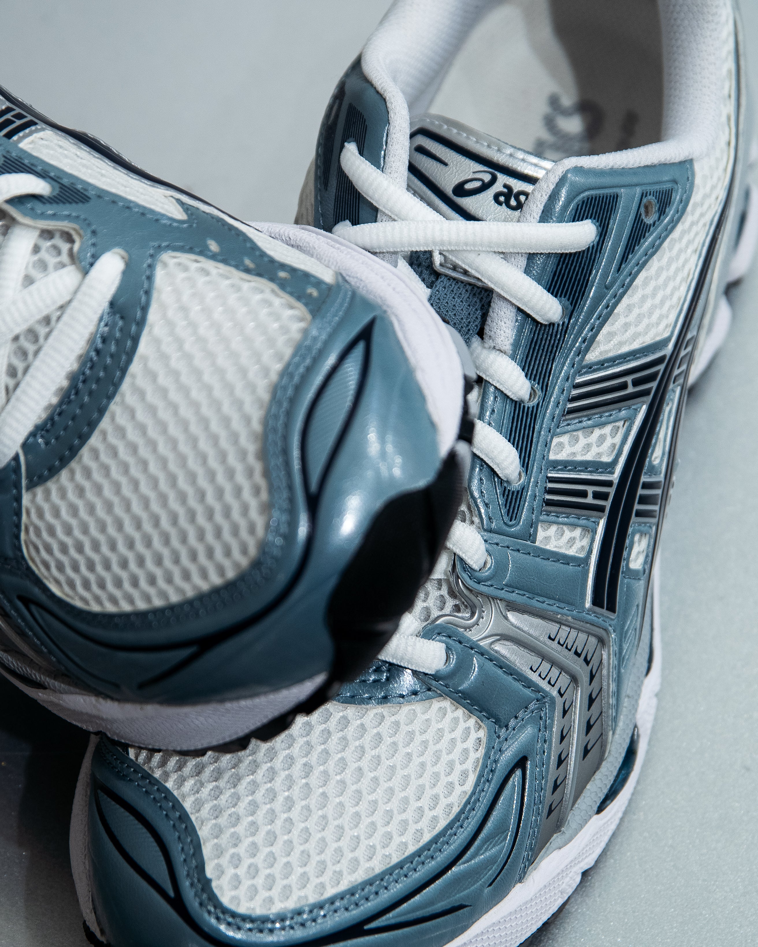 Close-up of blue and white running shoes with visible Asics logo.