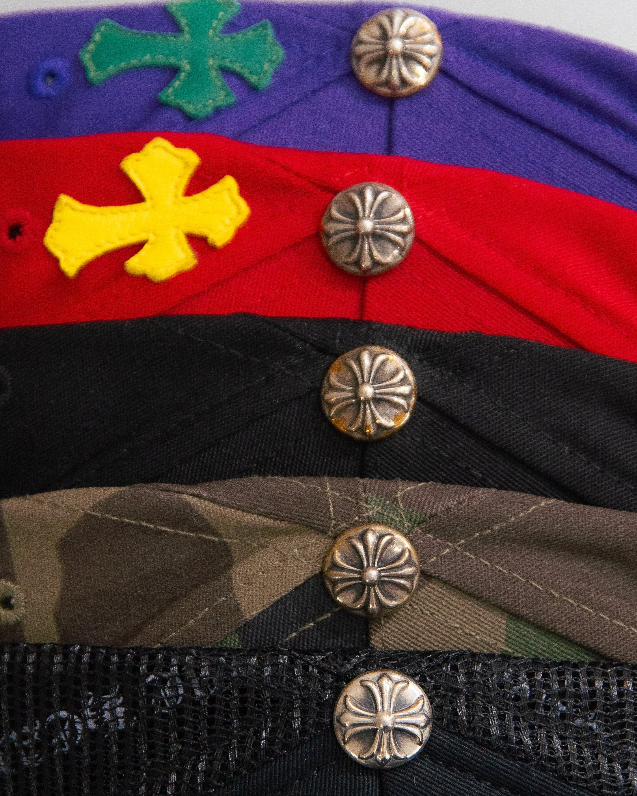 Close-up of a colorful Chrome Hearts caps with embroidered designs and metal buttons